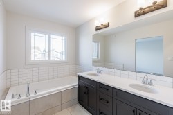 Full bathroom with double vanity and a garden tub - 