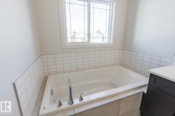 Bathroom featuring a garden tub and vanity - 