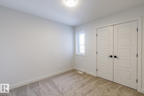 Unfurnished bedroom with light colored carpet and a closet - 3719 42 Avenue, Beaumont, AB - Indoor Photo Showing Other Room