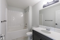 Full bathroom featuring shower / tub combination, vanity, and light tile patterned floors - 