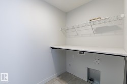 Laundry area with light tile patterned floors and hookup for a washing machine - 