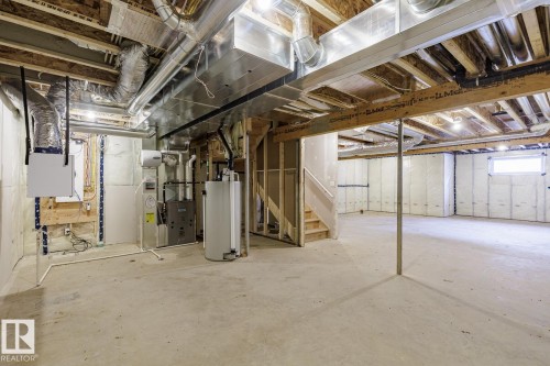 Basement featuring heating unit, water heater, and stairs - 3719 42 Avenue, Beaumont, AB - Indoor Photo Showing Basement