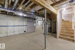 Unfinished below grade area with stairway, water heater, and heating unit - 