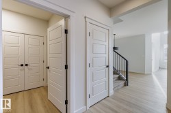 Corridor with light wood-style floors and stairway - 