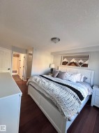 Bedroom with dark wood-style floors and a textured ceiling - 