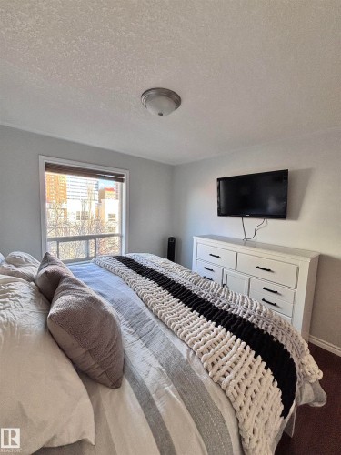 Bedroom with a textured ceiling and baseboards - 506 10046 110 Street, Edmonton, AB - Indoor Photo Showing Bedroom