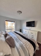 Bedroom with a textured ceiling and baseboards - 
