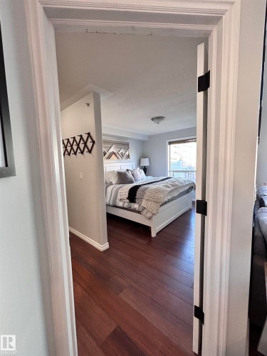Bedroom with dark wood-style flooring and baseboards - 506 10046 110 Street, Edmonton, AB - Indoor Photo Showing Bedroom