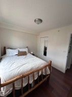 Bedroom with dark wood-style floors, a textured ceiling, and a closet - 
