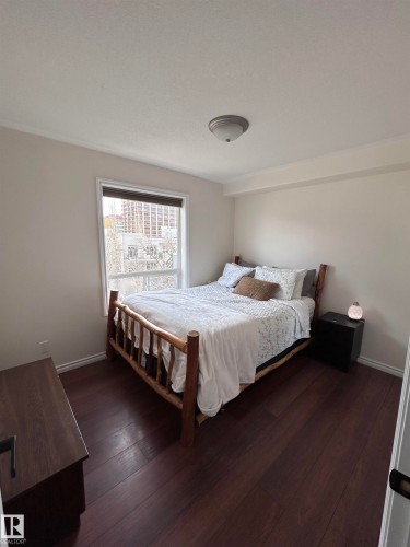 Bedroom featuring dark wood finished floors and baseboards - 506 10046 110 Street, Edmonton, AB - Indoor Photo Showing Bedroom