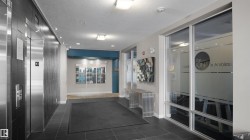 Corridor featuring dark tile patterned floors, elevator, and a textured ceiling - 