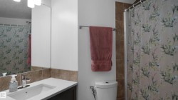 Bathroom with vanity, a shower with shower curtain, and decorative backsplash - 