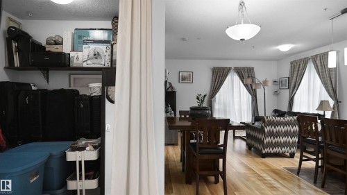 Dining area with light wood-type flooring and a textured ceiling - 105 2584 Anderson Way, Edmonton, AB - Indoor