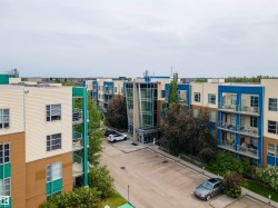 View of apartment building / complex with uncovered parking - 