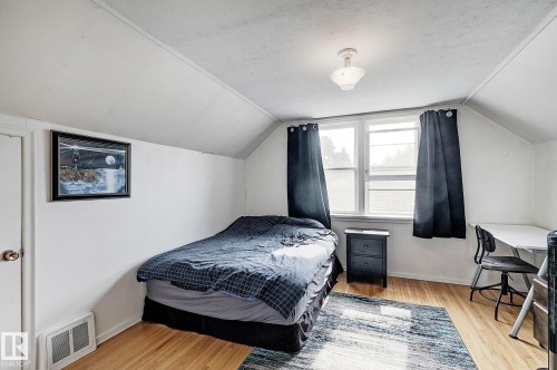 Bedroom featuring light wood-type flooring, a textured ceiling, and vaulted ceiling - 11559 80 Avenue, Edmonton, AB - Indoor Photo Showing Bedroom