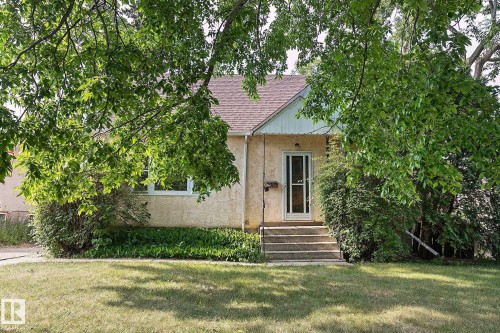 View of front of home with stucco siding, a front yard, and roof with shingles - 11559 80 Avenue, Edmonton, AB - Outdoor