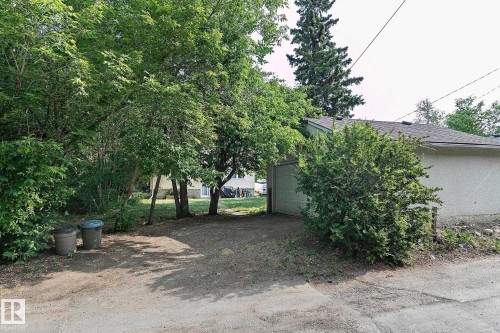 View of yard featuring a garage and driveway - 11559 80 Avenue, Edmonton, AB - Outdoor
