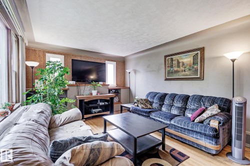 Living room with wood finished floors and a textured ceiling - 11559 80 Avenue, Edmonton, AB - Indoor Photo Showing Living Room