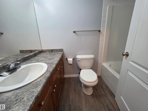 Bathroom with vanity, dark wood finished floors, and bathtub / shower combination - 106 4903 47 Avenue, Stony Plain, AB - Indoor Photo Showing Bathroom