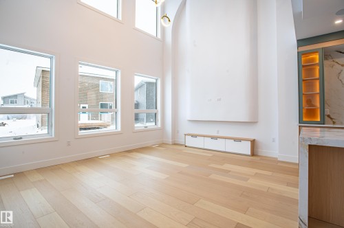 Unfurnished living room featuring light wood-style flooring and a high ceiling - 43 Eldridge Point(E), St. Albert, AB - Indoor Photo Showing Other Room