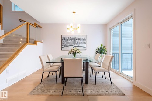 Dining space featuring healthy amount of natural light, a chandelier, stairs, and light wood-style floors - 43 Eldridge Point(E), St. Albert, AB - Indoor Photo Showing Dining Room