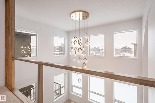 Hallway with a chandelier and plenty of natural light - 43 Eldridge Point(E), St. Albert, AB - Indoor Photo Showing Other Room