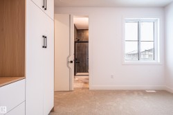 Unfurnished bedroom with connected bathroom and light carpet - 