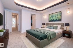 Bedroom featuring carpet, a tray ceiling, and arched walkways - 