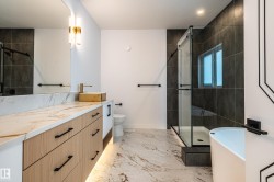 Full bathroom featuring vanity, a soaking tub, a shower stall, and light marble finish flooring - 