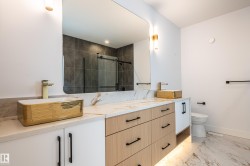 Full bath with a stall shower, light marble finish floors, and double vanity - 