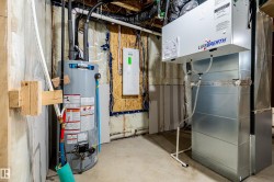 Utility room with heating unit, gas water heater, and electric panel - 