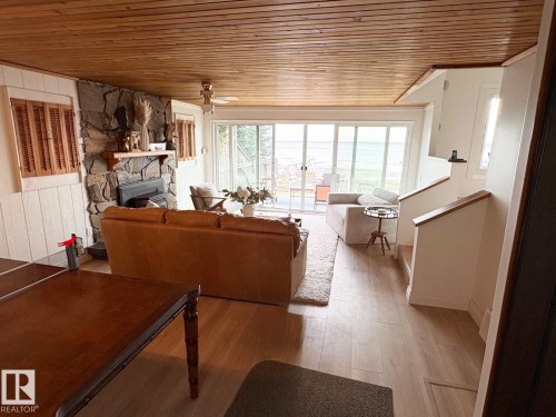 Living room featuring wooden ceiling, a fireplace, wood finished floors, and a ceiling fan - A15 Wicks Street, Rural Leduc County, AB - Indoor With Fireplace