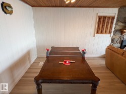 Playroom featuring wood ceiling, wooden walls, and light wood finished floors - 