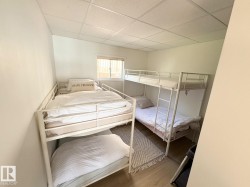 Bedroom featuring a drop ceiling and wood finished floors - 