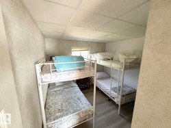 Bedroom featuring a paneled ceiling, dark wood-style floors, and a textured wall - 