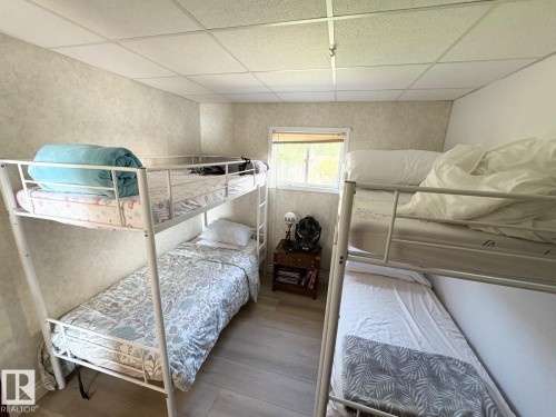 Bedroom with a paneled ceiling and wood finished floors - A15 Wicks Street, Rural Leduc County, AB - Indoor Photo Showing Bedroom