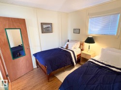 Bedroom with wood finished floors, a decorative wall, and a textured ceiling - 