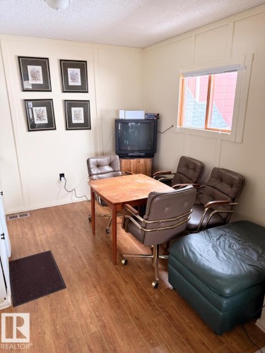Office with a decorative wall, a textured ceiling, and light wood-style floors - A15 Wicks Street, Rural Leduc County, AB - Indoor