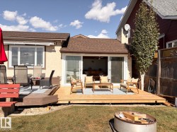 Back of property featuring a shingled roof, a wooden deck, an outdoor living space, and a lawn - 