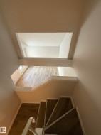 Open concept view from the top of the stairs down to living room. - 