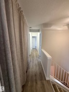Hallway featuring LVP finished floors, a textured ceiling, and an upstairs landing. Washroom off to left, bedroom 2 off to right, bedroom 3 straight ahead. - 