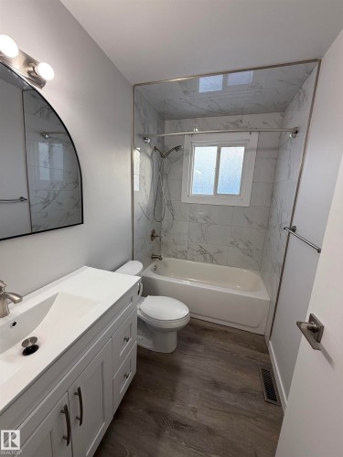 Bathroom featuring vanity, washtub / shower combination, and LVP finished floors - 23 Lancaster Terrace, Edmonton, AB - Indoor Photo Showing Bathroom