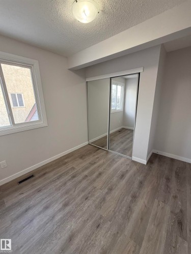 Unfurnished bedroom featuring a textured ceiling, a closet, and wood finished floors - 23 Lancaster Terrace, Edmonton, AB - Indoor Photo Showing Other Room