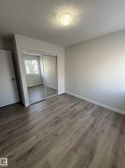 Bedroom 3 featuring LVP wood style  finished floors, a textured ceiling, and a closet - 