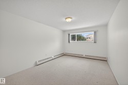 Carpeted spare room with a textured ceiling and a baseboard heating unit - 