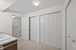 Full bathroom with a closet, vanity, a textured ceiling, and light colored carpet - 