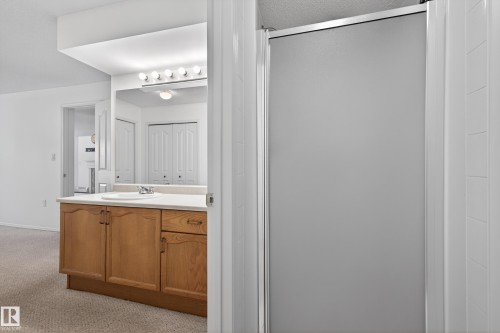 Bathroom featuring light colored carpet, vanity, and a stall shower - 106 15499 Castle Downs Road, Edmonton, AB - Indoor Photo Showing Bathroom