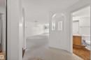 Corridor with a textured ceiling, arched walkways, and a baseboard radiator - 106 15499 Castle Downs Road, Edmonton, AB  - Indoor Photo Showing Other Room 