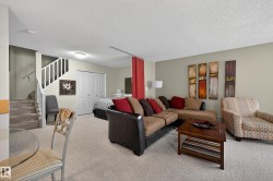 Carpeted living area featuring stairs and a textured ceiling - 