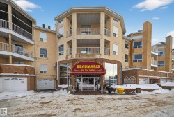 Snow covered building featuring a view of apartment building / complex - 